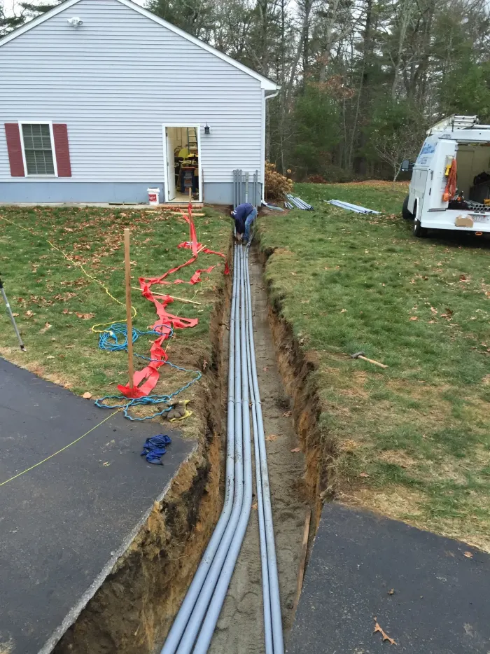 Long conduit trench dug across a lawn to a house